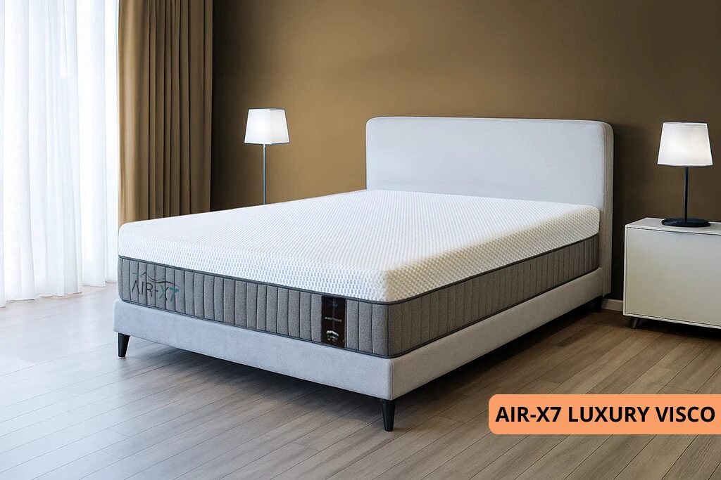 מזרן LUXURY VISCO מסדרת AIR-X7 עם מיטה סגנונית בחדר מעוצב עם קיר בצבע חום בהיר ווילונות בצבע חום בהיר